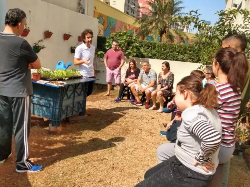 Palestra educativa sobre horta comunitária para moradores de condomínio.